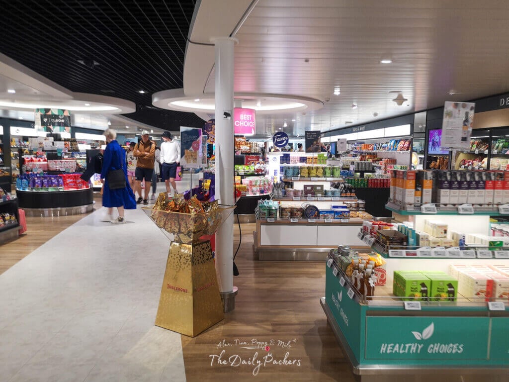 Modern duty-free shop onboard the ferry with snacks, drinks, souvenirs, and passengers browsing