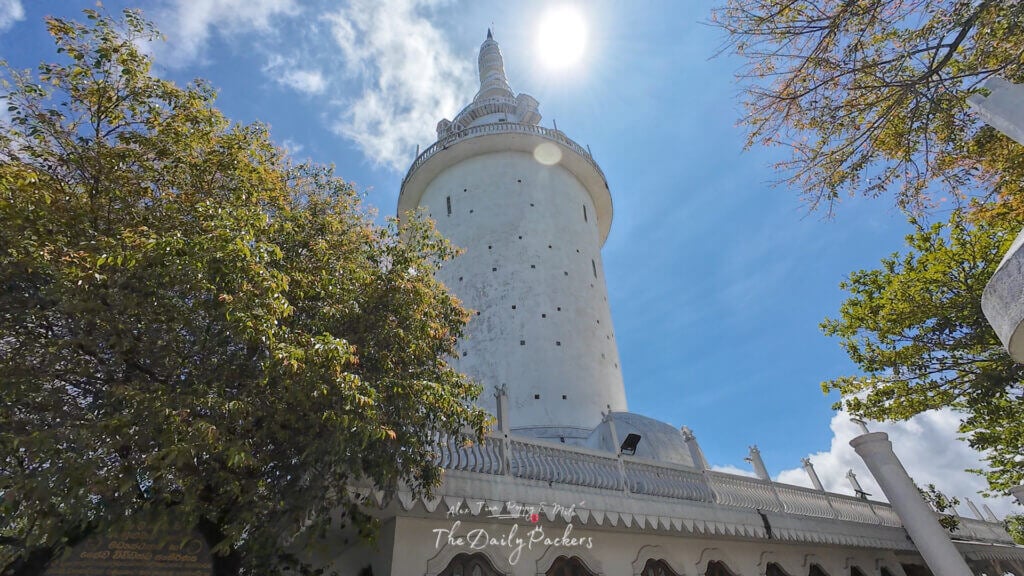 Vue de la base de la tour d'Ambuluwawa, au Sri Lanka, en direction de son sommet en spirale, sur fond de ciel bleu.