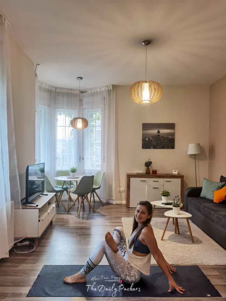 Woman doing yoga in a cozy Budapest Airbnb with modern decor and natural light
