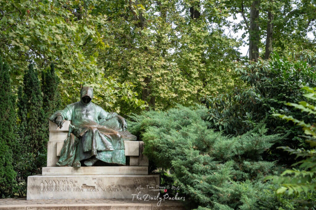 Statue of Anonymous in a shaded garden near Vajdahunyad Castle in Budapest