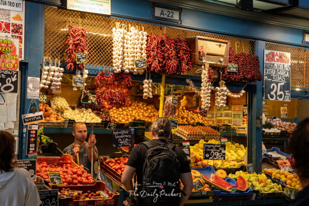 Colorful fruit and vegetable stall in Central Market Hall with hanging garlic and peppers