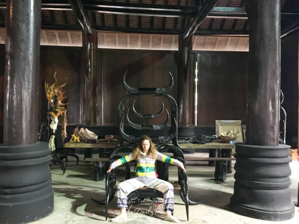 Femme assise sur une chaise noire sculptée à l'intérieur de l'étrange et artistique musée Baan Dam à Chiang Rai, en Thaïlande.