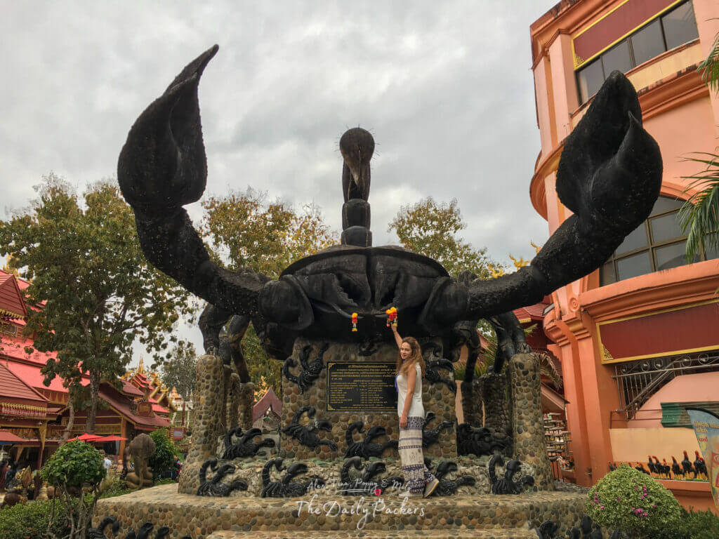 Statue géante de scorpion noir au Wat Phra That Doi Wao avec une femme debout à sa base