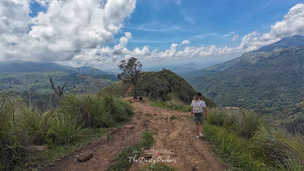 Hiker walking along the trail to the second viewpoint of Little Adam’s Peak under a dramatic sky