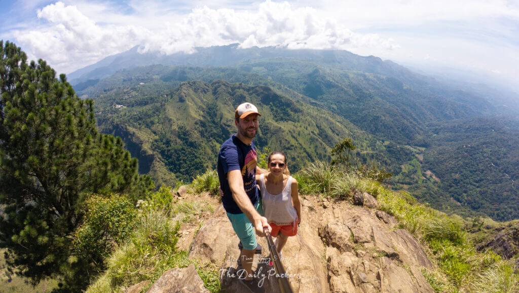 Couple au sommet du rocher d'Ella, avec une vue spectaculaire sur les vallées verdoyantes et les crêtes montagneuses.