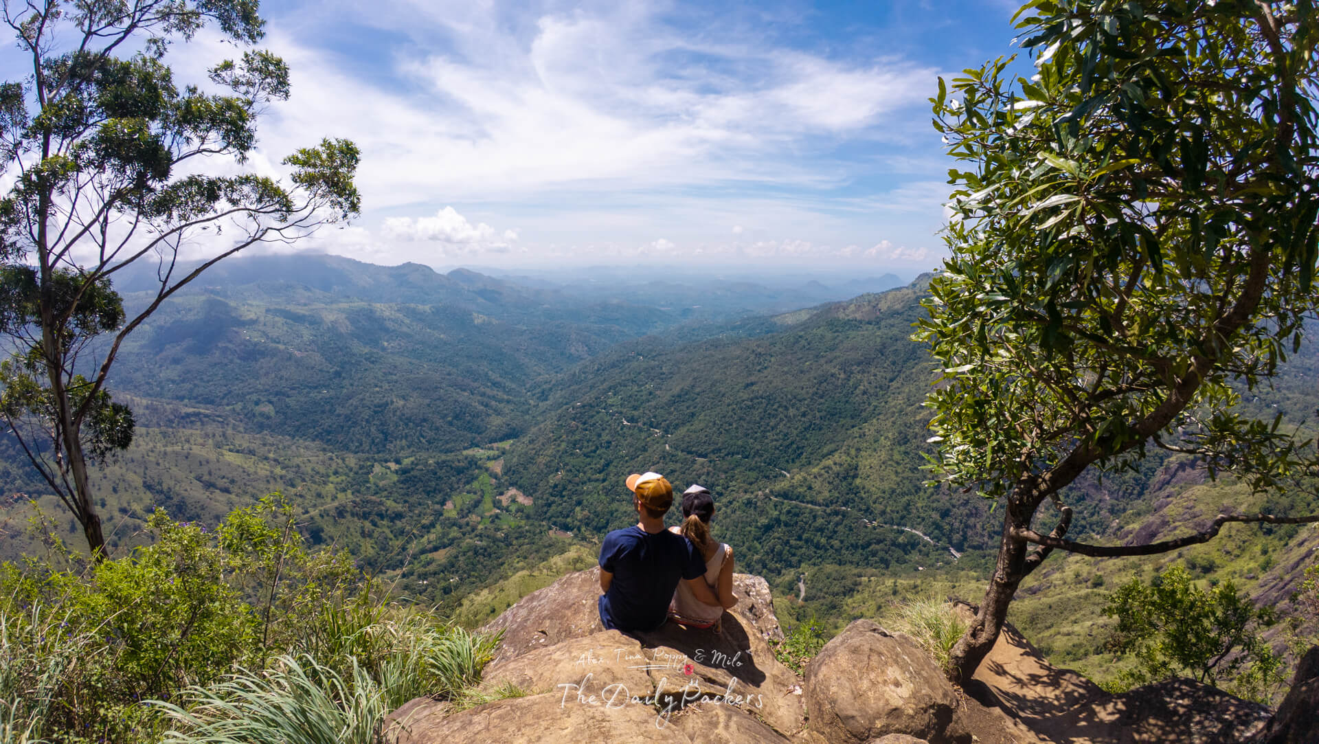 Couple sitting on the edge at Ella Rock’s second viewpoint overlooking lush Sri Lankan mountains