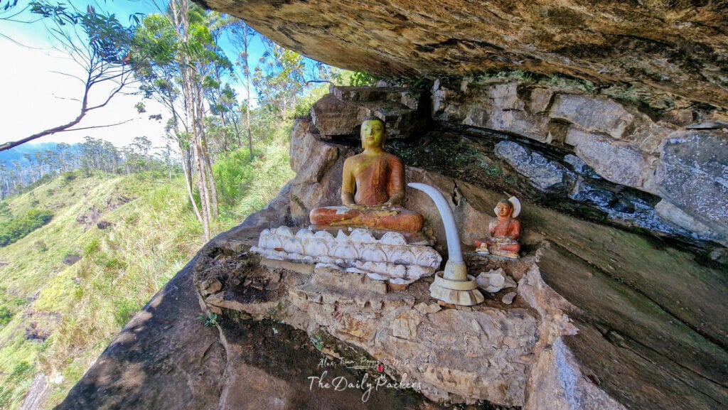 Sanctuaire bouddhiste creusé dans la roche sur le sentier du rocher d'Ella, entouré d'arbres et de paysages montagneux.