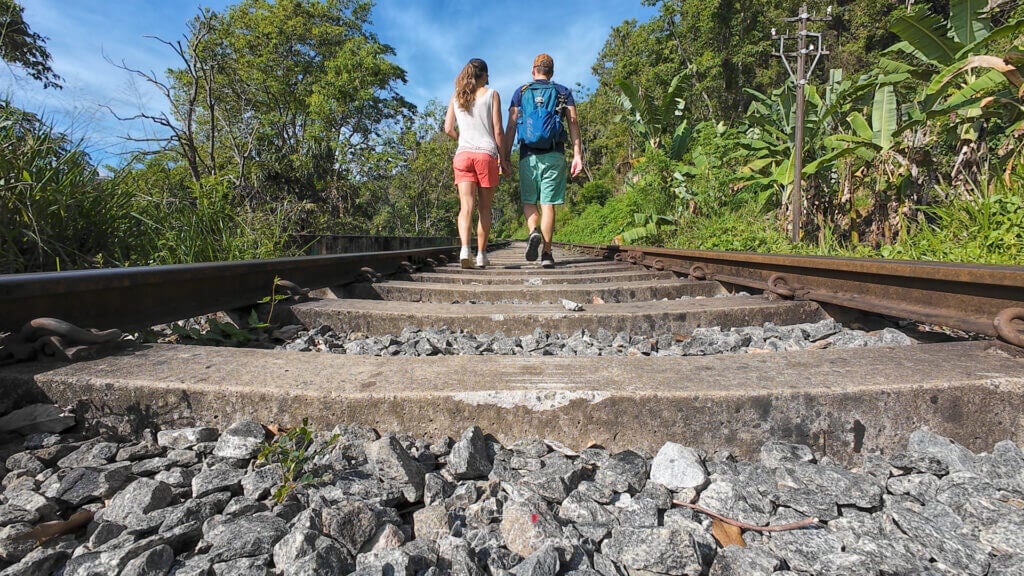 Angle bas d'un couple se tenant la main tout en marchant sur les voies ferrées près d'Ella Rock.
