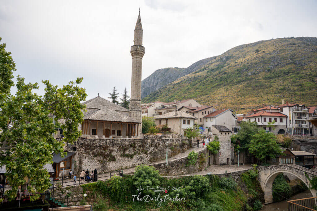Vue large du pont Kriva Ćuprija avec les maisons d'hôtes et les ruelles pavées qui l'entourent à Mostar.