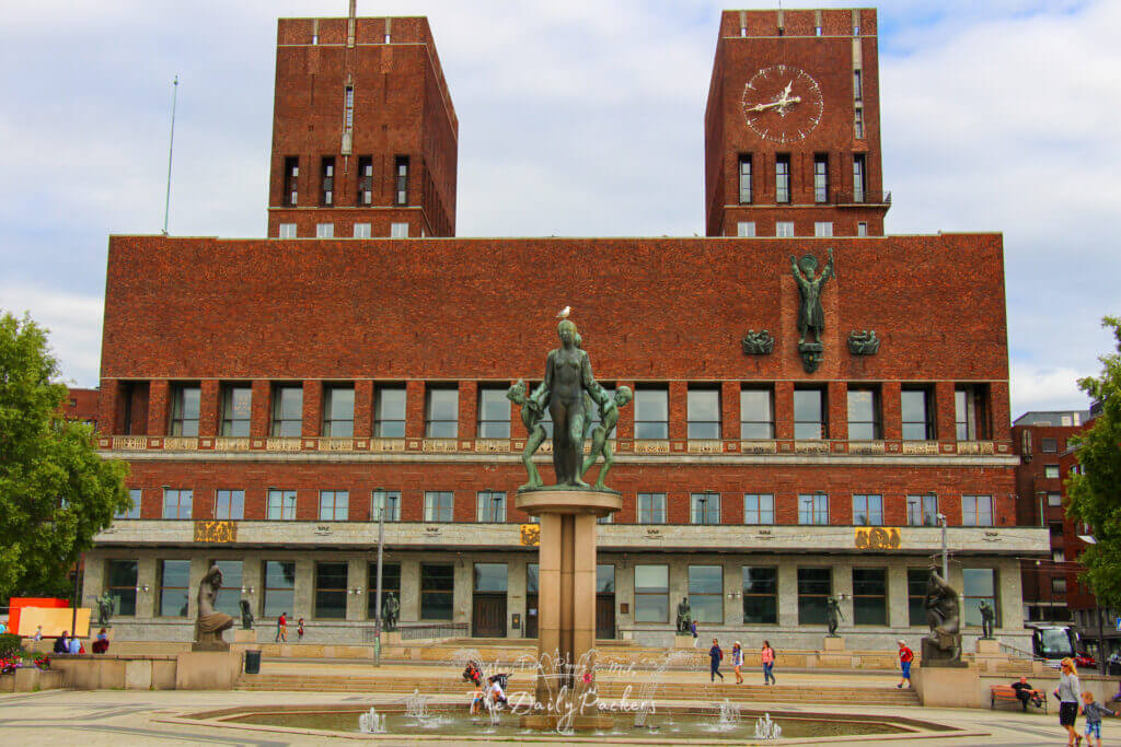 L'hôtel de ville d'Oslo avec ses tours jumelles en briques et la place de la fontaine au premier plan