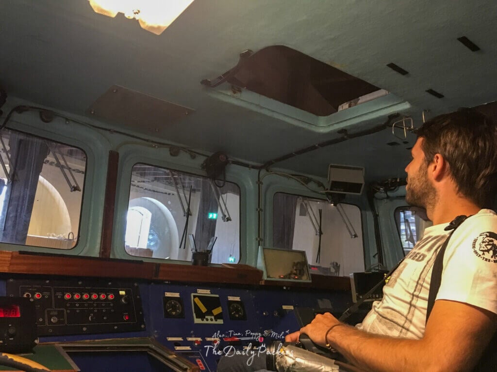 Homme explorant l'intérieur d'un navire historique exposé au musée de la Résistance norvégienne à Oslo.