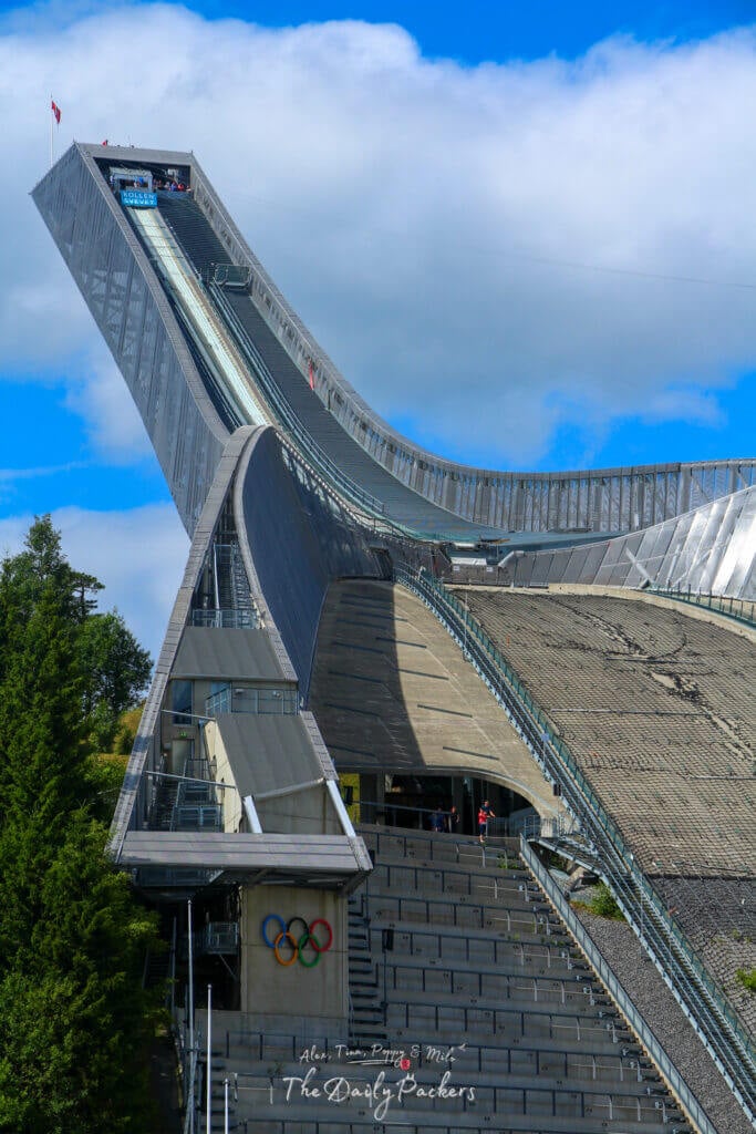 Vue rapprochée de la structure du tremplin de saut à ski de Holmenkollen avec les anneaux olympiques et un design moderne