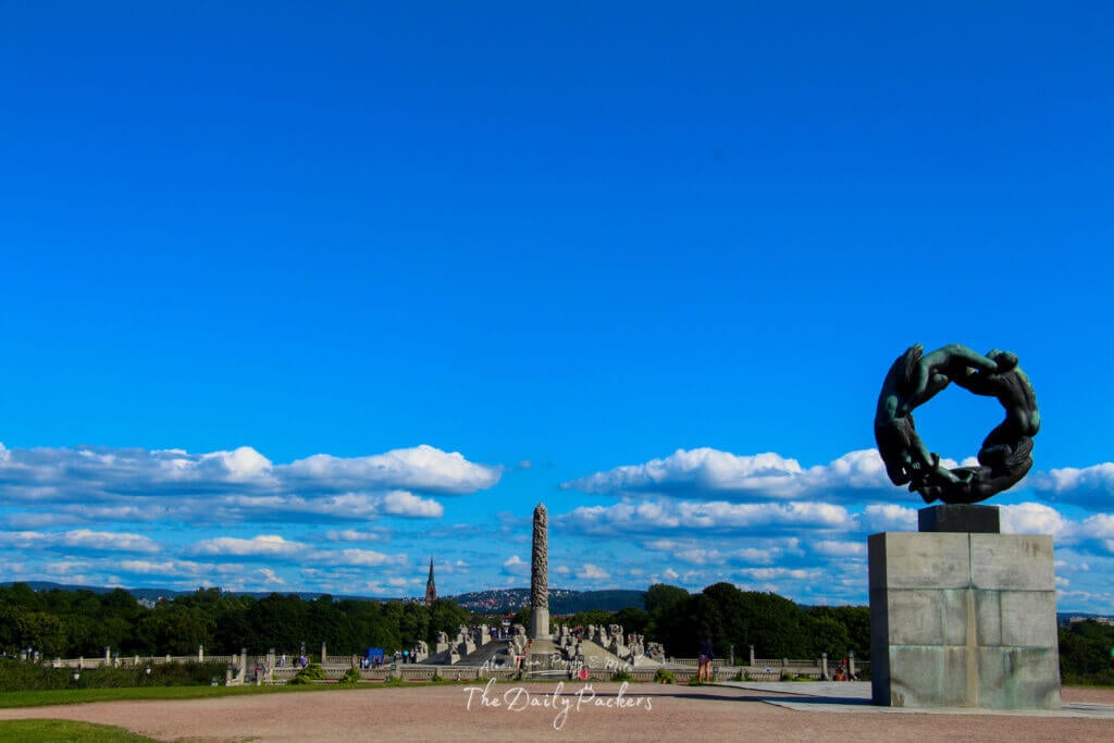 Sculpture Circle of Life et monolithe visible au loin au parc Vigeland