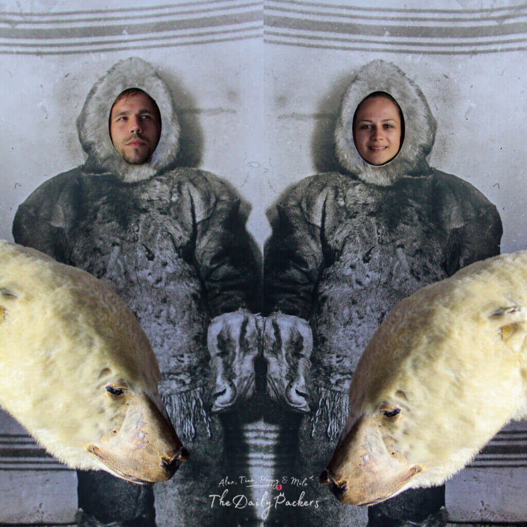 Couple posant derrière des sculptures d'explorateurs polaires au musée Fram d'Oslo, avec un accessoire d'ours polaire devant.