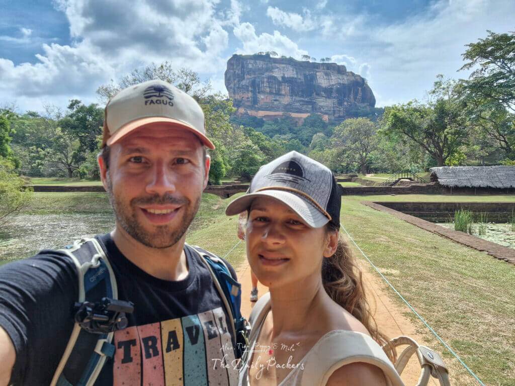 Couple souriant devant le célèbre rocher du lion de Sigiriya lors d'une journée ensoleillée au Sri Lanka.
