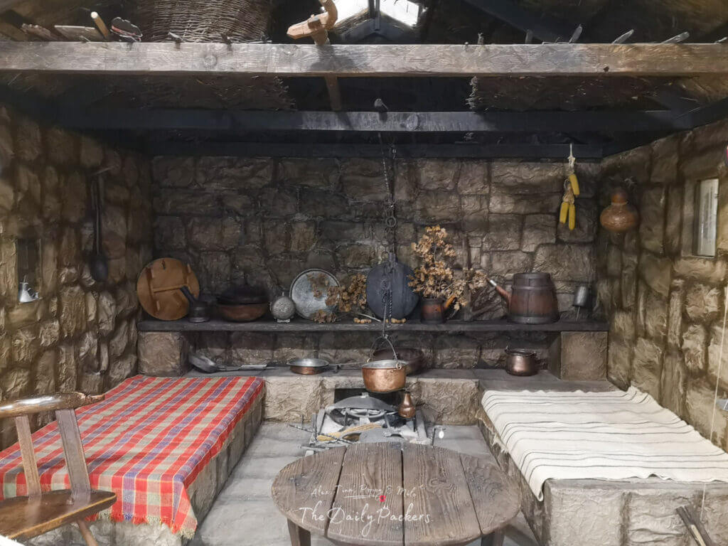 Traditional stone room in the Herzegovina Museum with rustic beds and antique kitchenware.