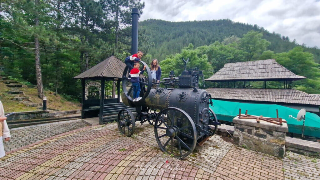 Children climbing on an old steam engine at Mokra Gora open-air museum in Serbia