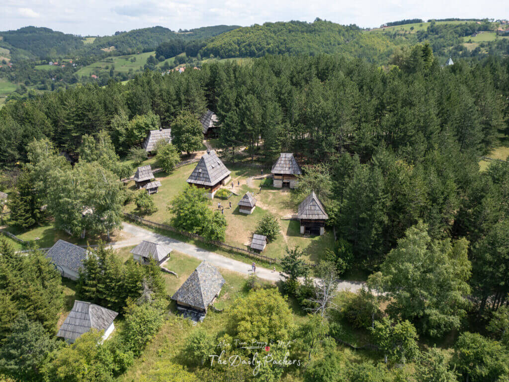 Aerial view of traditional wooden houses surrounded by forest in the open-air museum of Sirogojno, Serbia