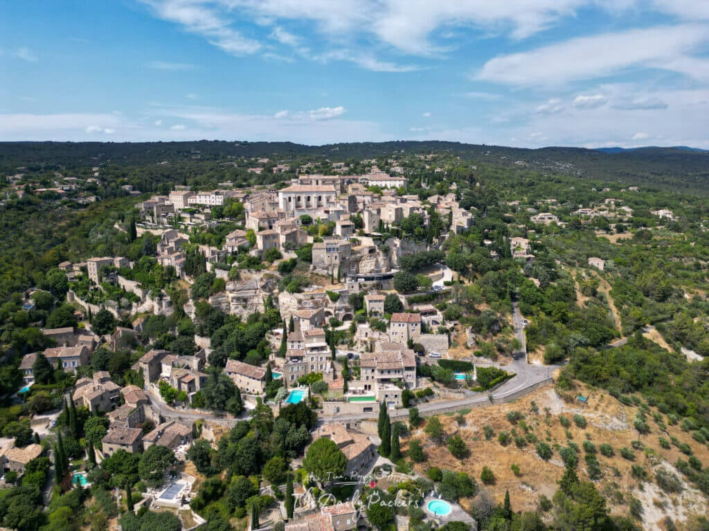 Aerial view of Gordes village showing stone houses, narrow streets, and surrounding Provence countryside.