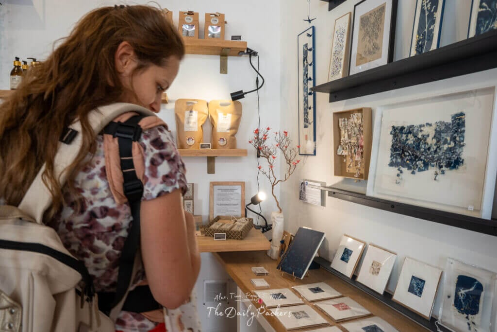 Femme regardant des objets d'art et des produits faits à la main dans une petite boutique d'Arles