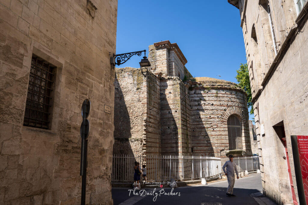 Vestiges des thermes romains d'Arles avec des murs en pierre usés par le temps sous un ciel bleu clair
