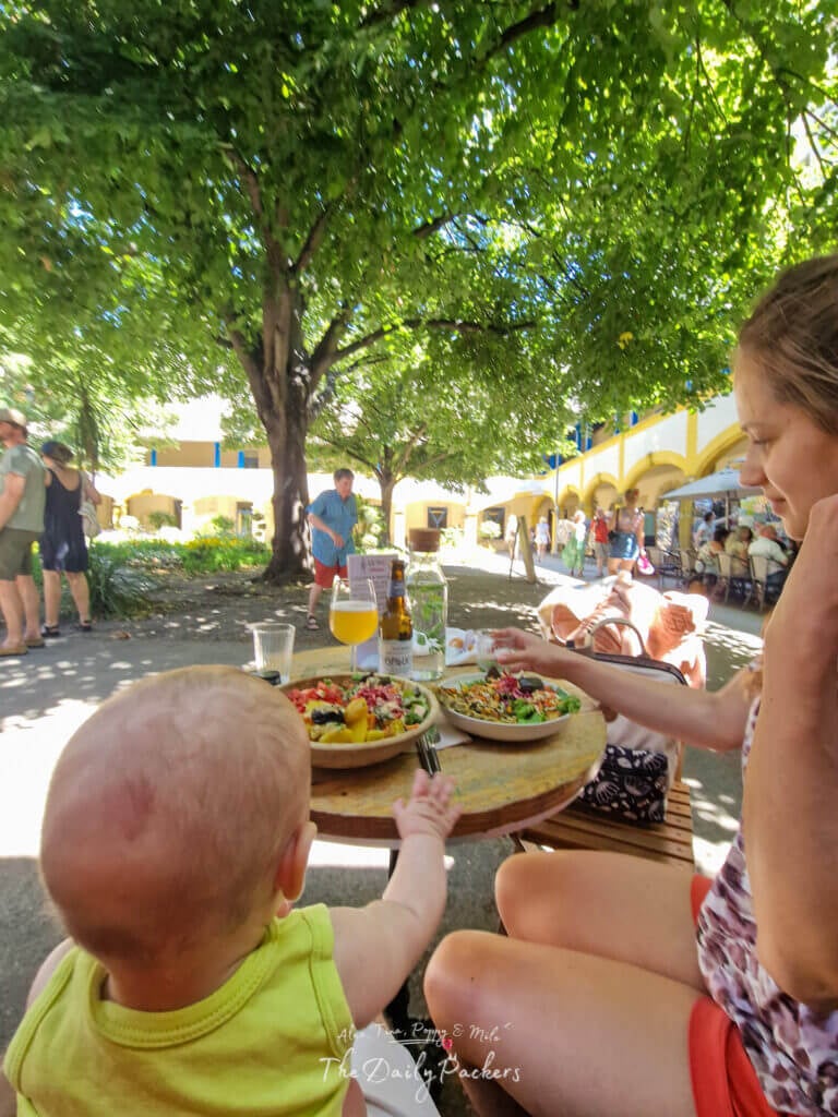 Salle à manger extérieure dans la cour du VG d'Arles avec les visiteurs à l'ombre des arbres