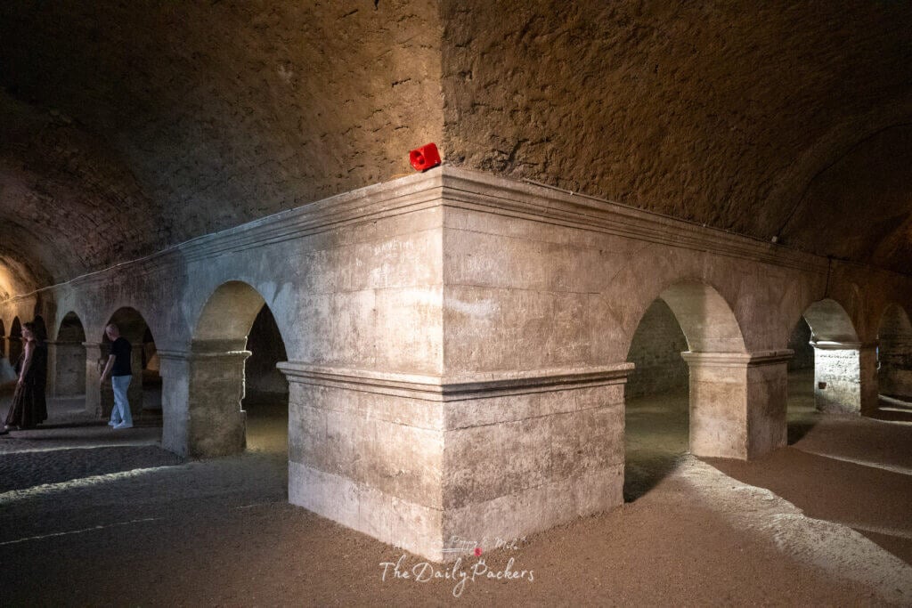 Cryptoportique romain souterrain à Arles avec des arches en pierre et un éclairage tamisé.