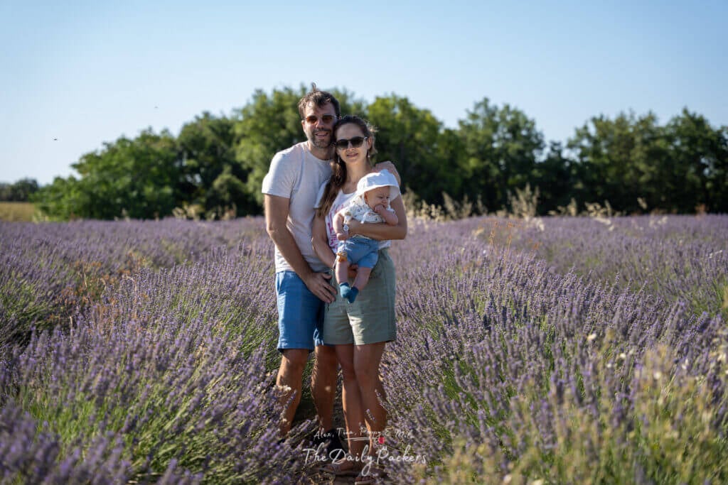 Family with baby standing together in the middle of a vibrant lavender field