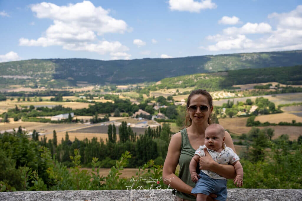 Femme tenant son bébé avec une vue panoramique de la vallée de Sault et des champs de lavande au loin