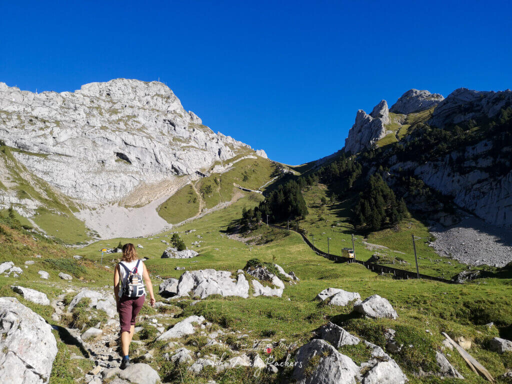 Femme marchant sur un sentier alpin escarpé entouré de pentes rocheuses sur le sentier menant à l'intersection du Matthorn.