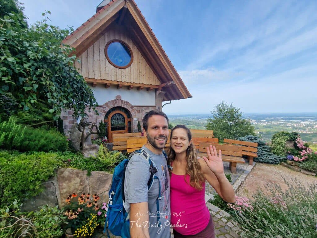 Couple devant une petite chapelle en bois avec vue sur les vignobles de Sasbachwalden