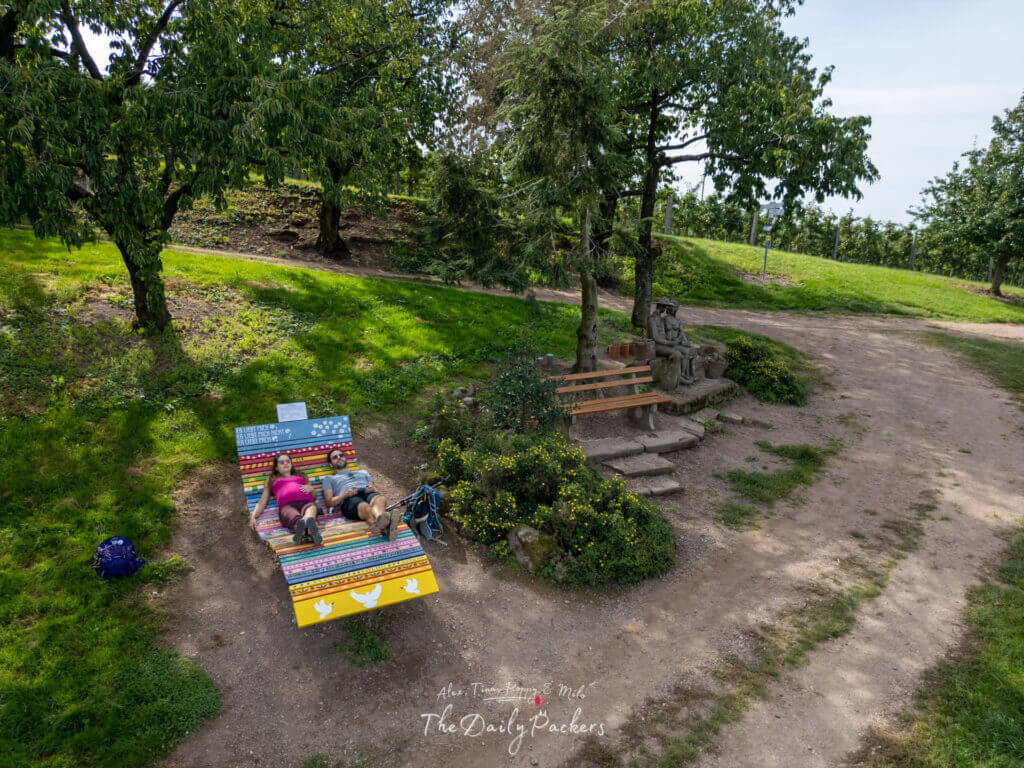 Deux randonneurs se reposant sur un banc en bois coloré à l'ombre des cerisiers près de Sasbachwalden.