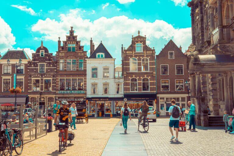 Main square in Delft with outdoor café terraces and view of historic buildings