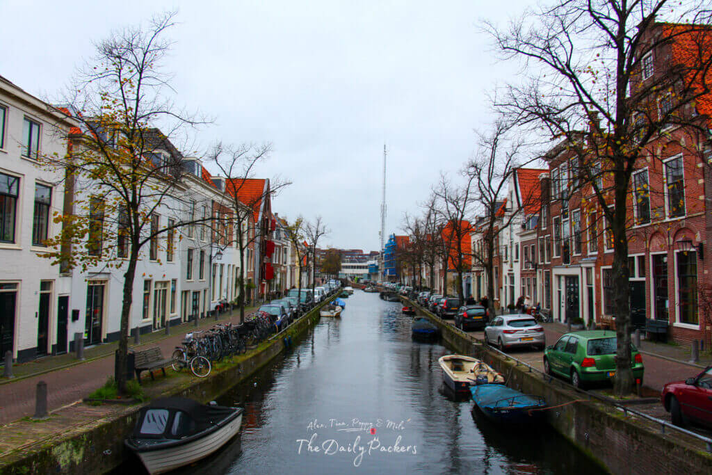 Quiet inner canal in Haarlem with small boats moored along both sides and traditional Dutch houses lining the street.