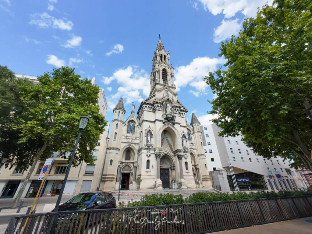 Extérieur de l'église Sainte-Perpétue à Nîmes, un bel édifice néogothique encadré d'arbres.