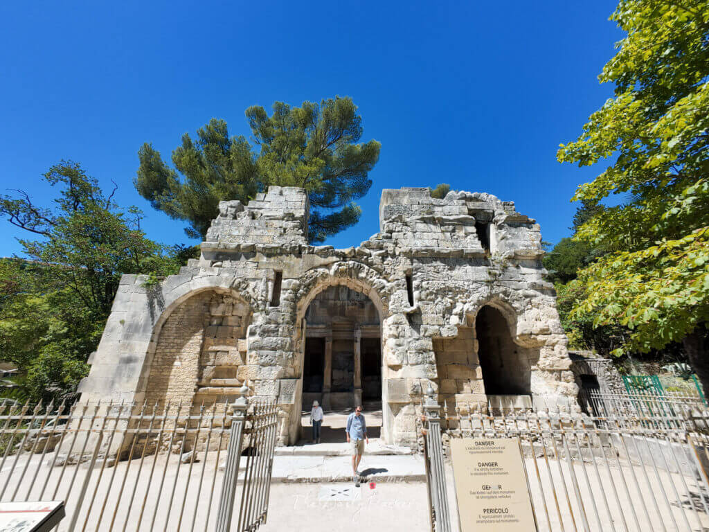 Extérieur du temple de Diane à Nîmes, avec ses arcs romains et ses murs de pierre anciens.
