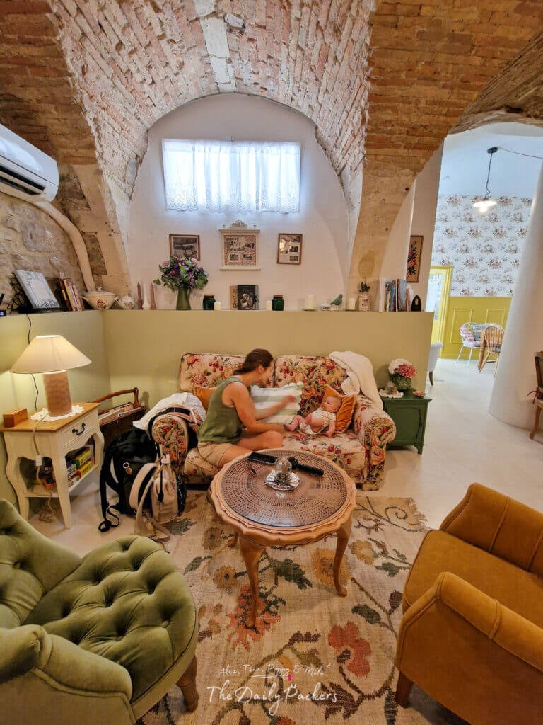 Salon confortable de style vintage au Cottage Annabelle à Nîmes, avec des meubles floraux et un plafond voûté en pierre.