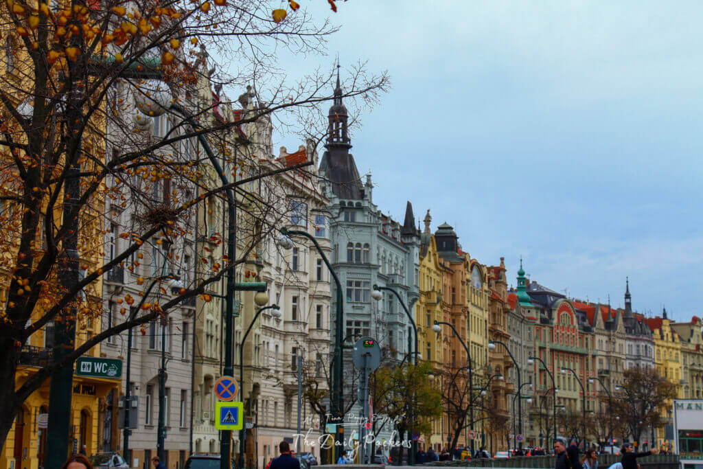 Pastel-colored facades along a busy street in Prague, showing the city’s charming architecture and lively street scene.