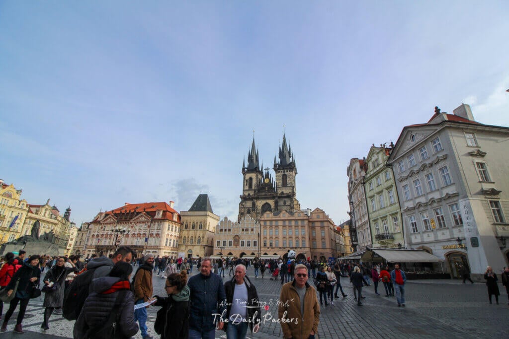 Wide view of Old Town Square in Prague, filled with tourists and historic buildings including Týn Church.