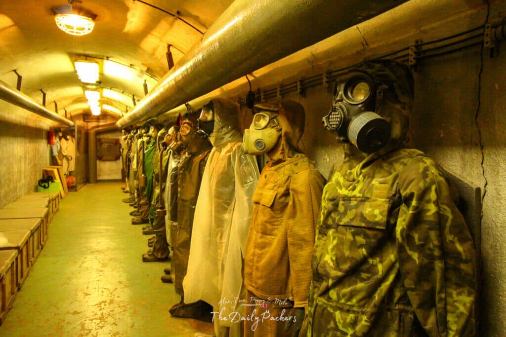 Exhibit of mannequins in gas masks and protective suits inside a Cold War nuclear bunker museum in Prague.