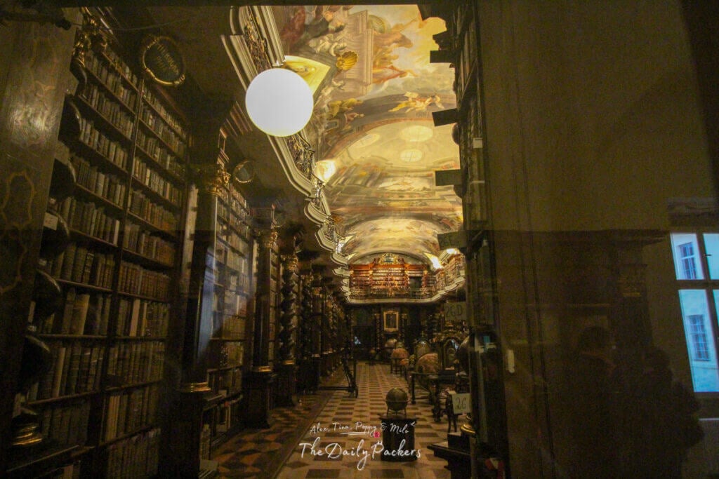 Inside the stunning Baroque library of the Strahov Monastery in Prague, with ceiling frescoes and antique books.