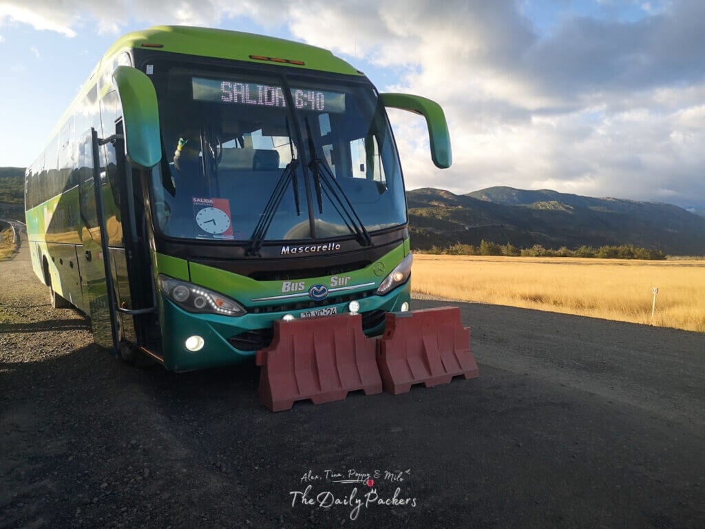 Green and blue Bus-Sur coach parked on a gravel road near Torres del Paine entrance.