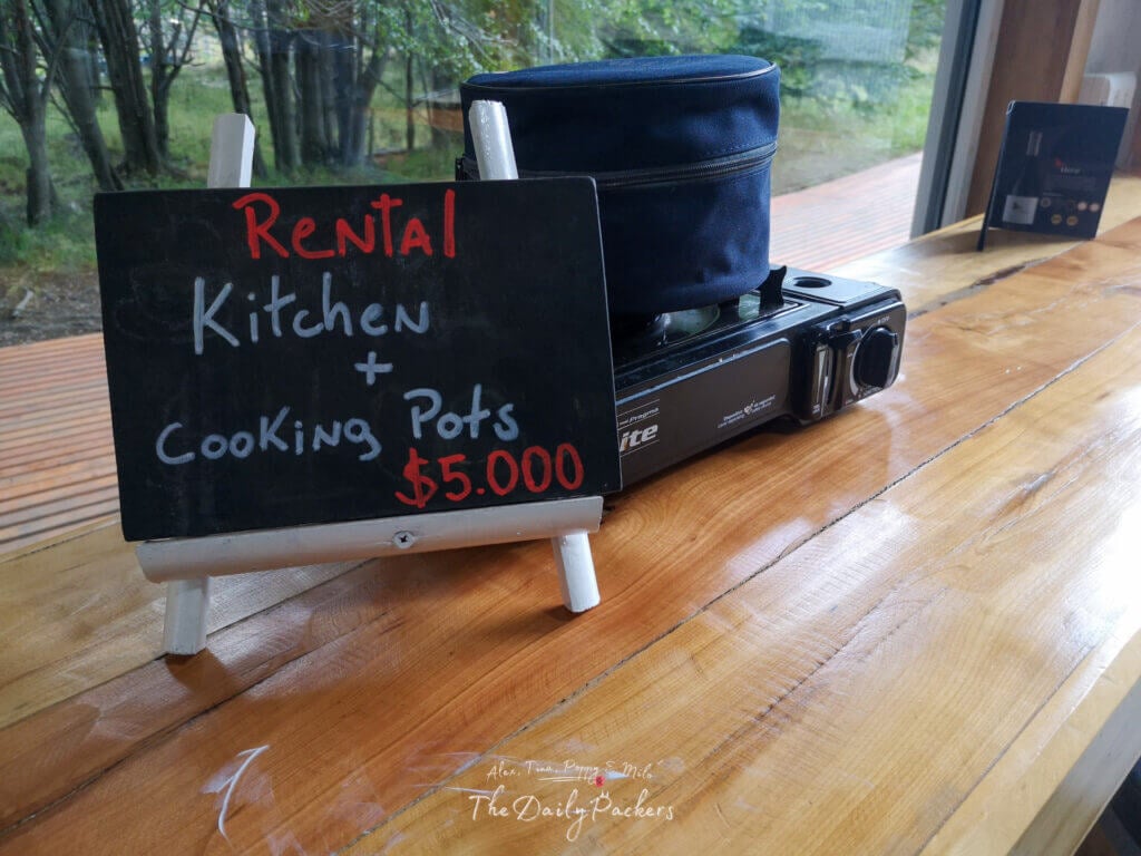 Tabletop display with a camping stove and a sign advertising rental kitchen and cooking pots at Refugio Grey store.