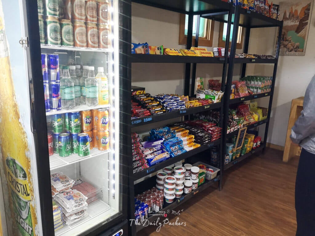 Shelves stocked with drinks, snacks, and instant food inside the Refugio Grey store in Torres del Paine.