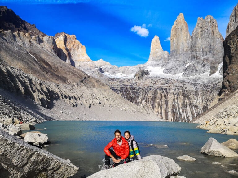 Couple posing by the turquoise Torres lagoon with the iconic granite towers rising dramatically in the background
