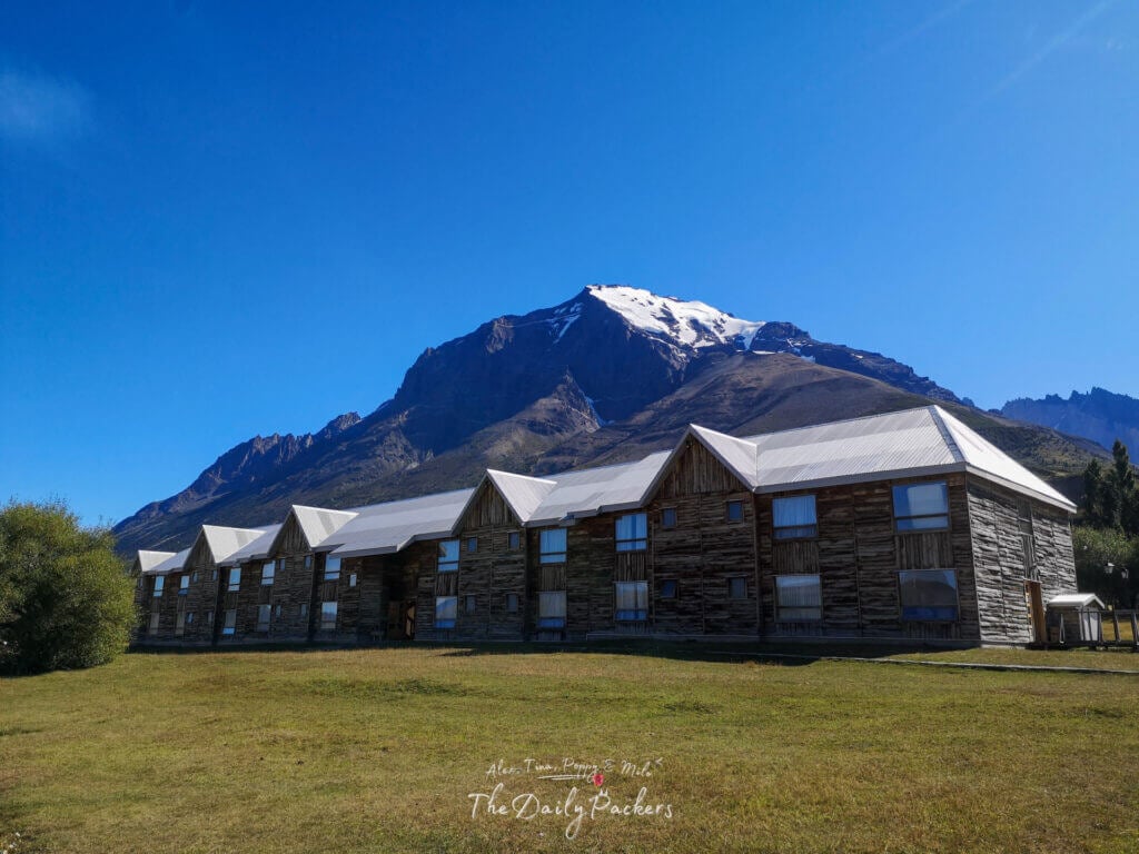 Refugio Central lodge encadré par une montagne enneigée et un ciel d'un bleu profond dans le parc national Torres del Paine