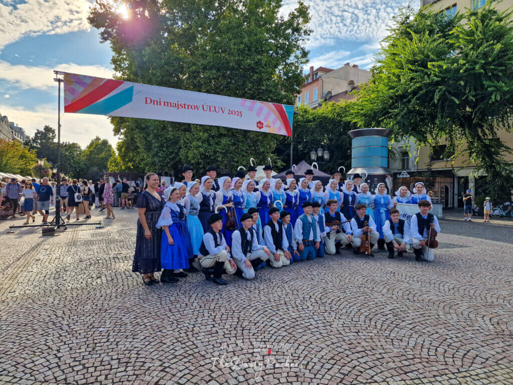 Groupe de danse folklorique traditionnelle en costumes colorés se produisant lors d'un festival sur la place Hviezdoslavovo à Bratislava.