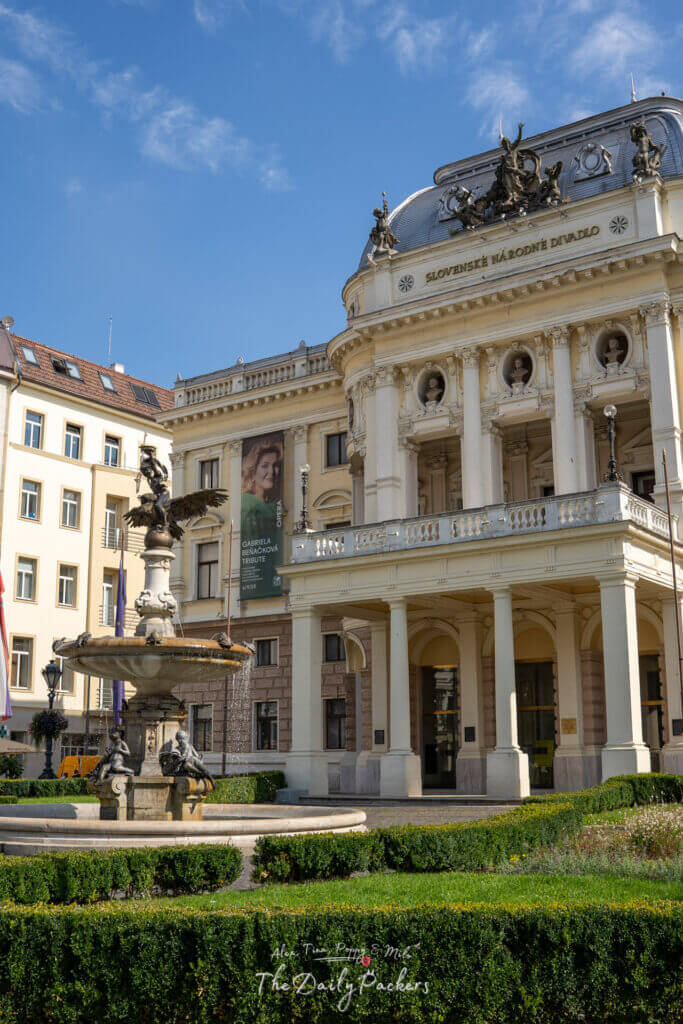 Close-up view of the Slovak National Theater building with ornate sculptures and fountain in front.