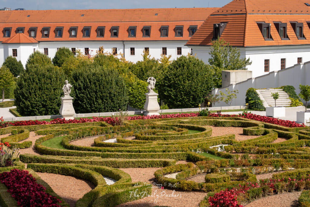 Close-up view of the ornate garden at Bratislava Castle, with detailed boxwood patterns, flowers, and statues.