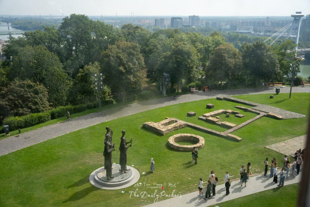 View of the Bratislava Castle courtyard with statues and garden structures visible from the window.